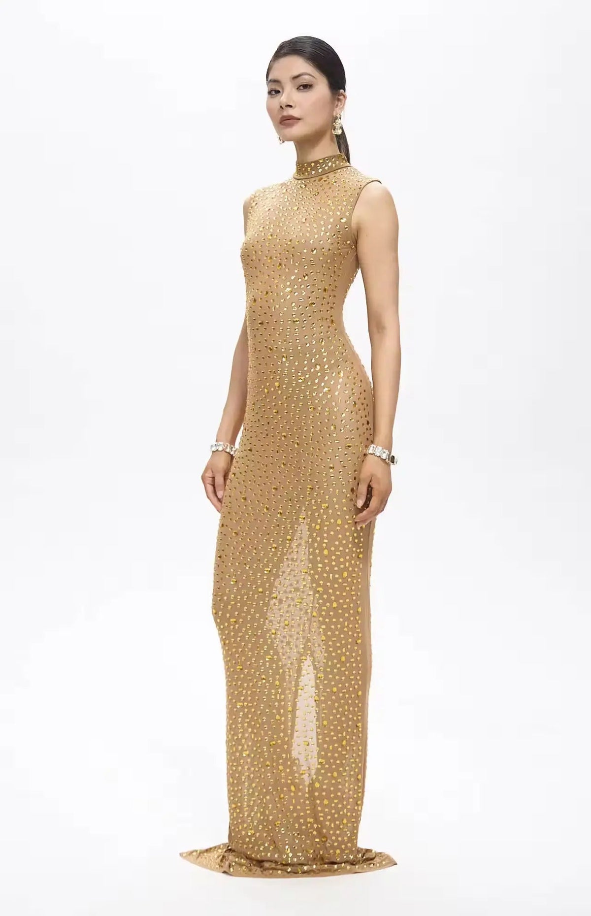 Woman wearing a gold sequin gown on a white background