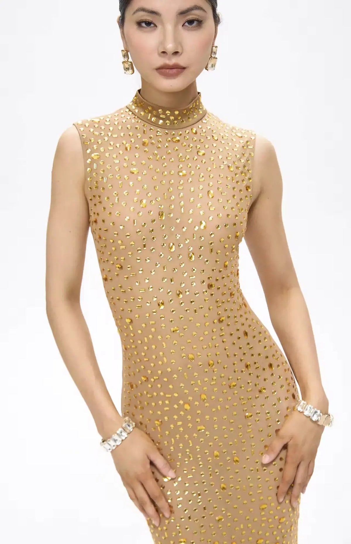 Woman wearing a gold beaded dress on a white background